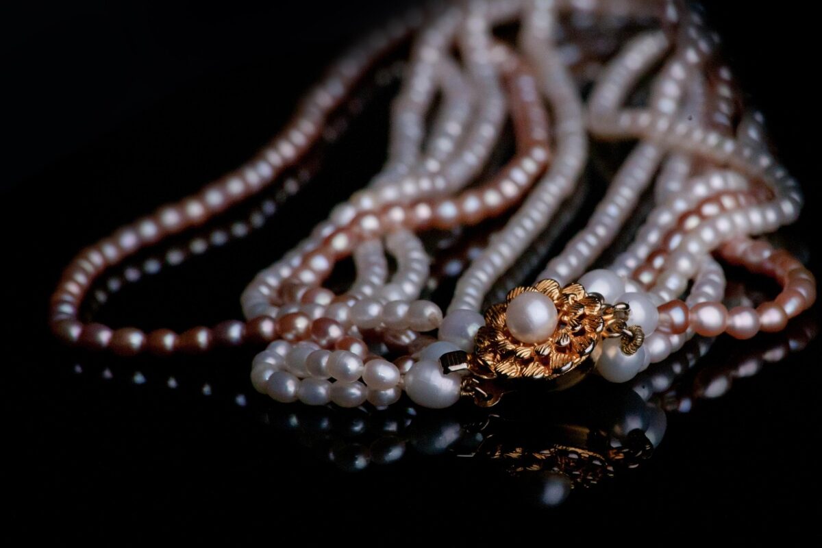 A pearl necklace laid on a plain background
