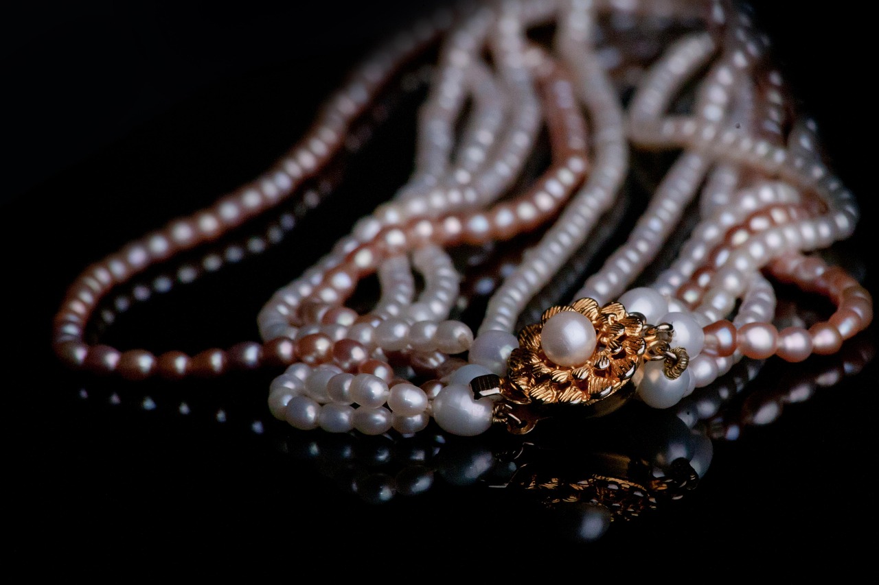 A pearl necklace laid on a plain background